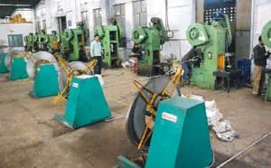 Washer manufacturing section: a row of green power presses, each fed with steel strip from a coil stand.