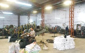 Cold forming section: a hall of forming machines with an operator at work and sacks of parts on the floor.